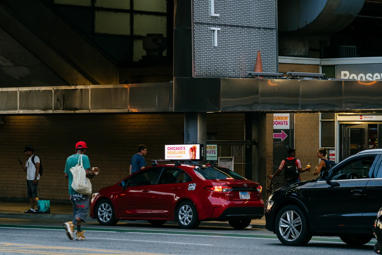 Dunkin' campaign on a digital car-top screen at CTA Roosevelt station, Chicago, 2024