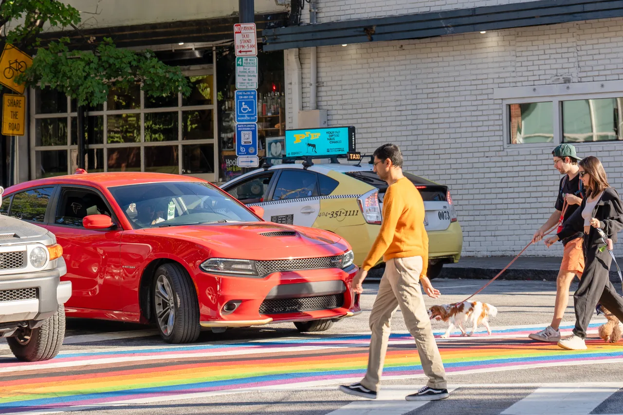 GSK campaign on a digital taxi-top screen at the rainbow crosswalk at 10th and Piedmont, Midtown, Atlanta, 2024