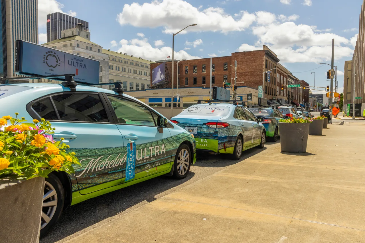 Michelob Ultra campaign on a swarm of wrapped cars with digital tops at Ted Turner Drive, four-car swarm during the Club World Cup, Atlanta, 2025