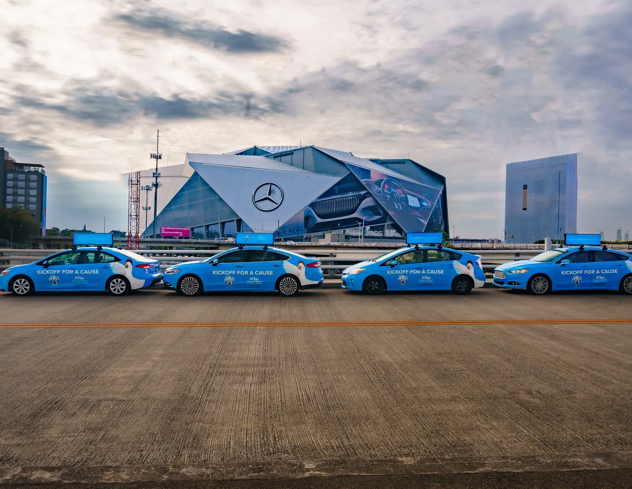 Aflac Kickoff Game campaign on a line of wrapped cars with digital tops at in front of Mercedes-Benz Stadium, four cars, Atlanta, 2023