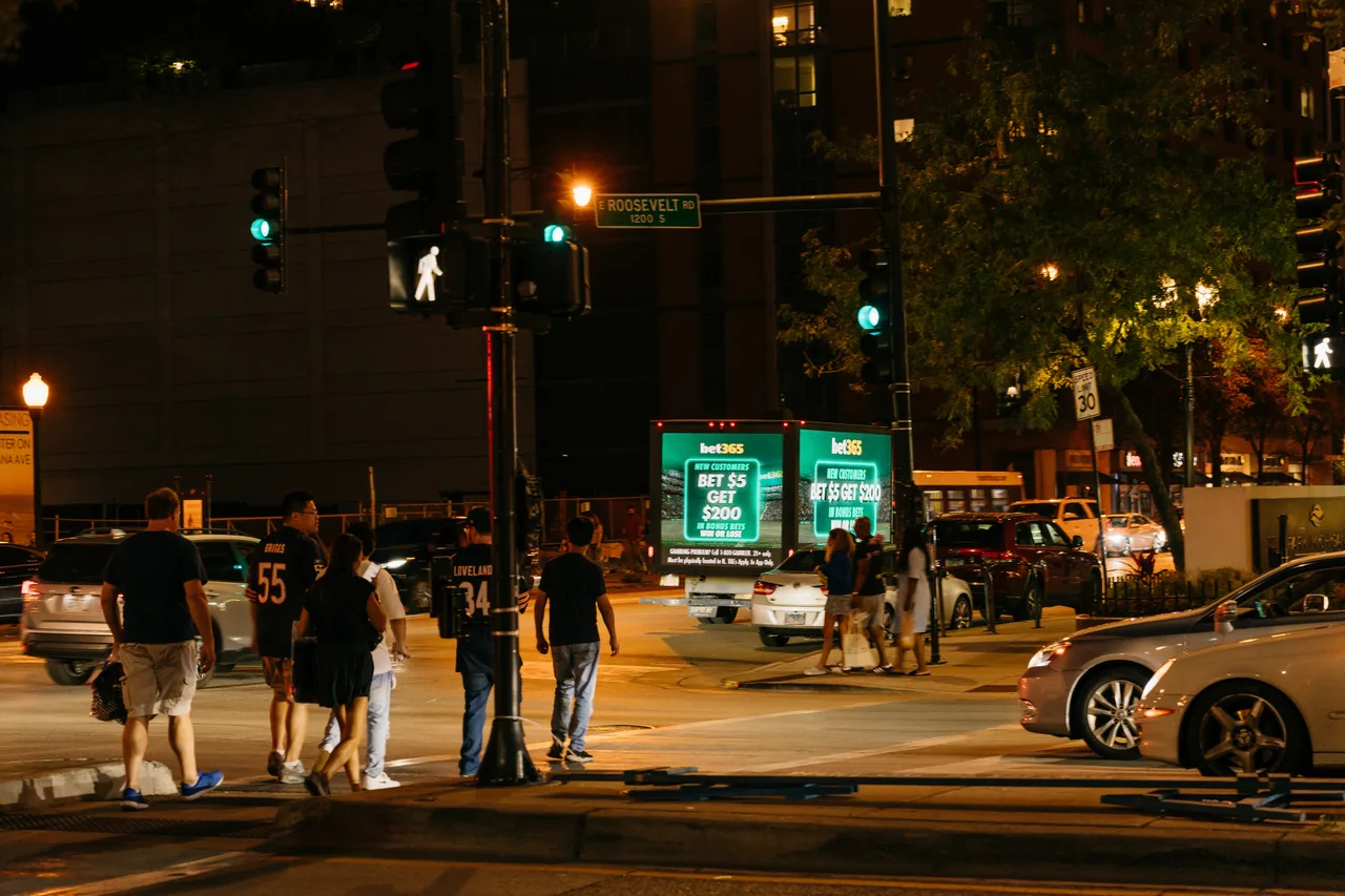 bet365 campaign on a pair of LED trucks at Roosevelt Road near Soldier Field, game night, Chicago, 2025