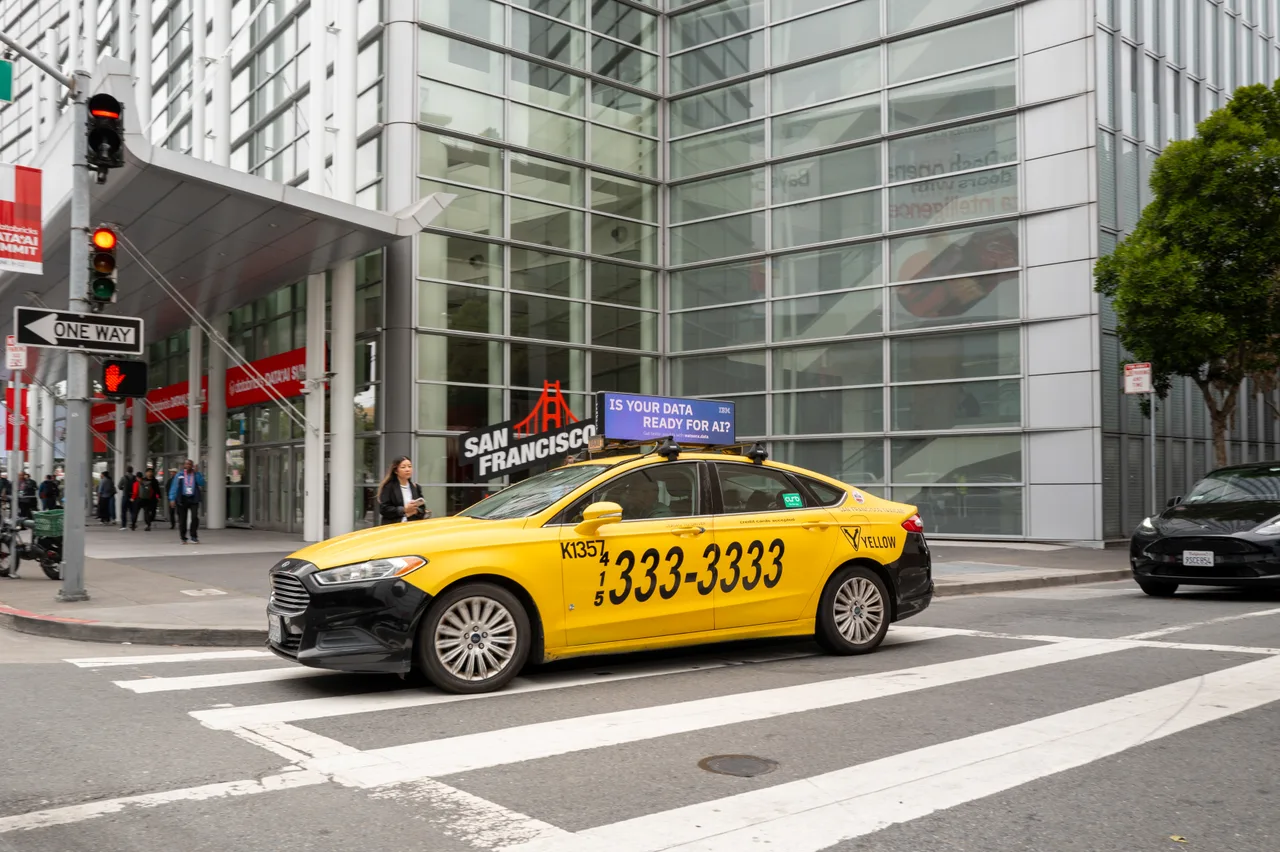 IBM campaign on a digital taxi-top screen at Moscone West during the Data + AI Summit, Yellow Cab, San Francisco, 2025
