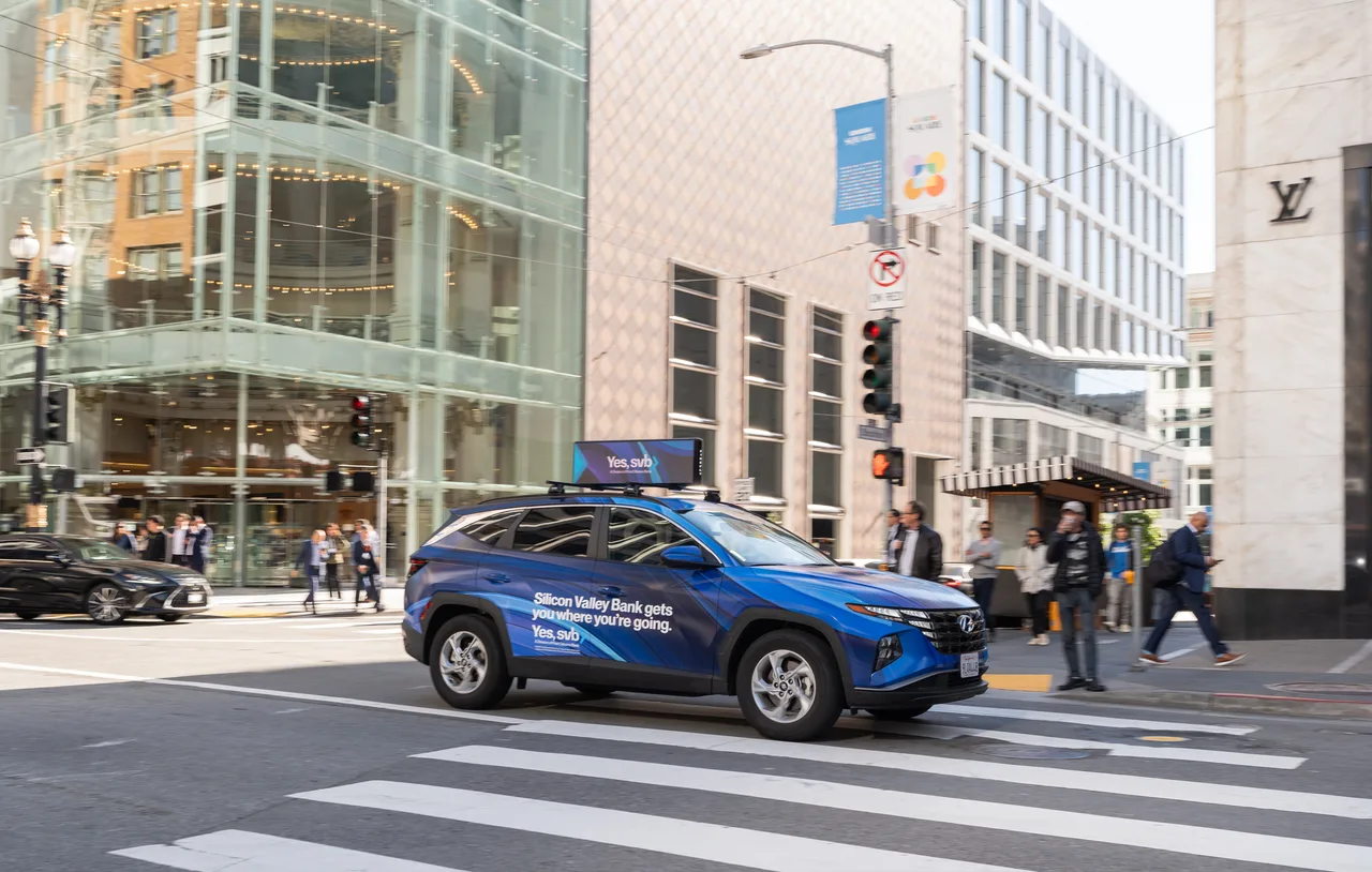 Silicon Valley Bank campaign on a wrapped car carrying a digital top at Union Square at the Apple Store, San Francisco, 2025