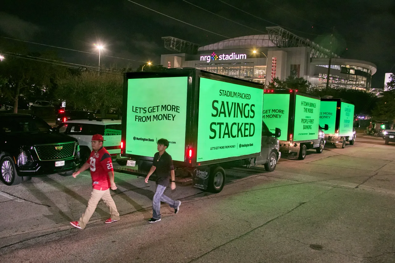 Huntington Bank campaign on a convoy of LED trucks at NRG Stadium at night, three-truck convoy, Houston, 2025