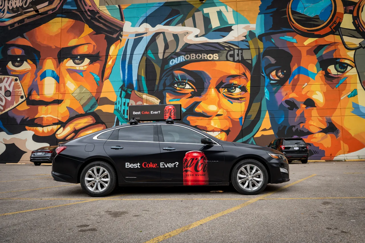 Coke Zero Sugar campaign on a wrapped car carrying a digital top at a mural wall, Houston, 2023
