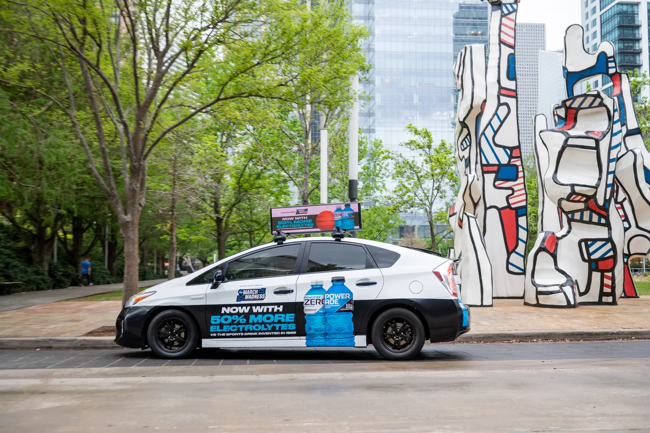 Powerade campaign on a wrapped car carrying a digital top at Discovery Green, beside the Dubuffet sculpture, Houston, 2023